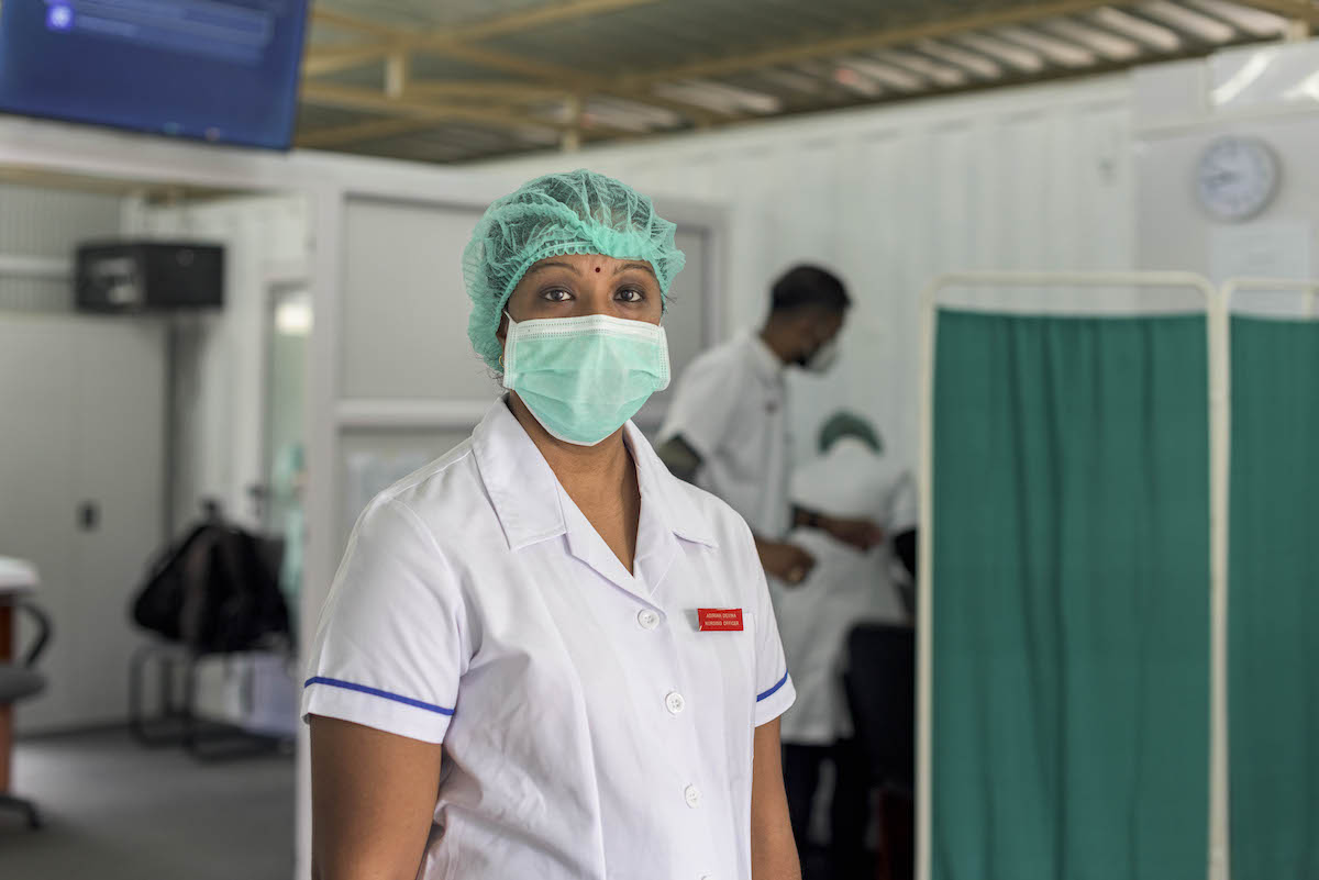 Female health worker in medical mask and haircover