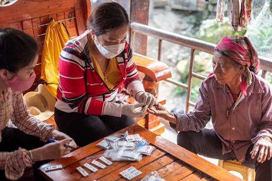 Health workers perform a malaria rapid diagnostic test